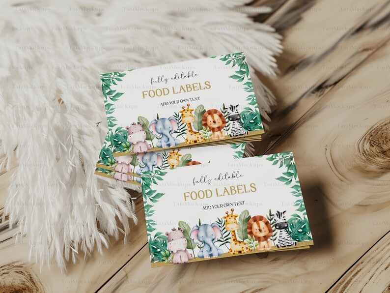 May include: A stack of food labels with a jungle theme. The labels feature illustrations of a hippo, elephant, giraffe, lion, and zebra. The text "fully editable FOOD LABELS ADD YOUR OWN TEXT" is printed on the labels.