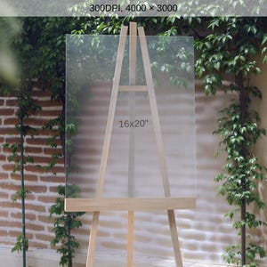 May include: A wooden easel with a clear acrylic panel, displaying the text "16x20". The easel is set against a backdrop of brick and greenery, suggesting an outdoor or garden setting. The panel is 16 inches by 20 inches.