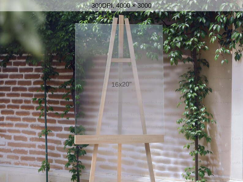 May include: A wooden easel with a clear acrylic panel, displaying the text "16x20". The easel is set against a backdrop of brick and greenery, suggesting an outdoor or garden setting. The panel is 16 inches by 20 inches.
