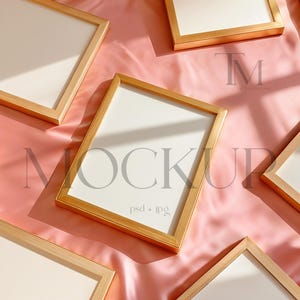 May include: Multiple gold-framed rectangular mockups are arranged on a pink satin surface. The frames have a light wood appearance and white interiors. The word "MOCKUP" is visible in the center, along with "psd + jpg".