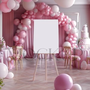 Puede incluir: Un lienzo blanco en blanco sobre un caballete frente a un arco de globos rosa y blanco. Los globos están dispuestos en forma de cascada. Hay una mesa puesta con manteles rosas y sillas en el fondo.
