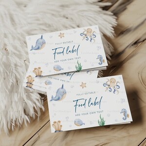 May include: A stack of white food labels with an ocean theme. Each label features watercolor illustrations of sea creatures like narwhals, octopuses, and seahorses. The text "Food label" and "Add your own text" are visible.
