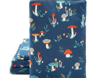 May include: A blue fabric notebook cover with a mushroom pattern. The cover has a white stitched border and a gold tassel.