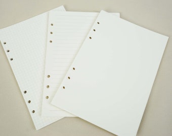 May include: Three white sheets of paper with punched holes along the side. The sheets are blank, but one has a grid pattern, one has lines, and one is plain.