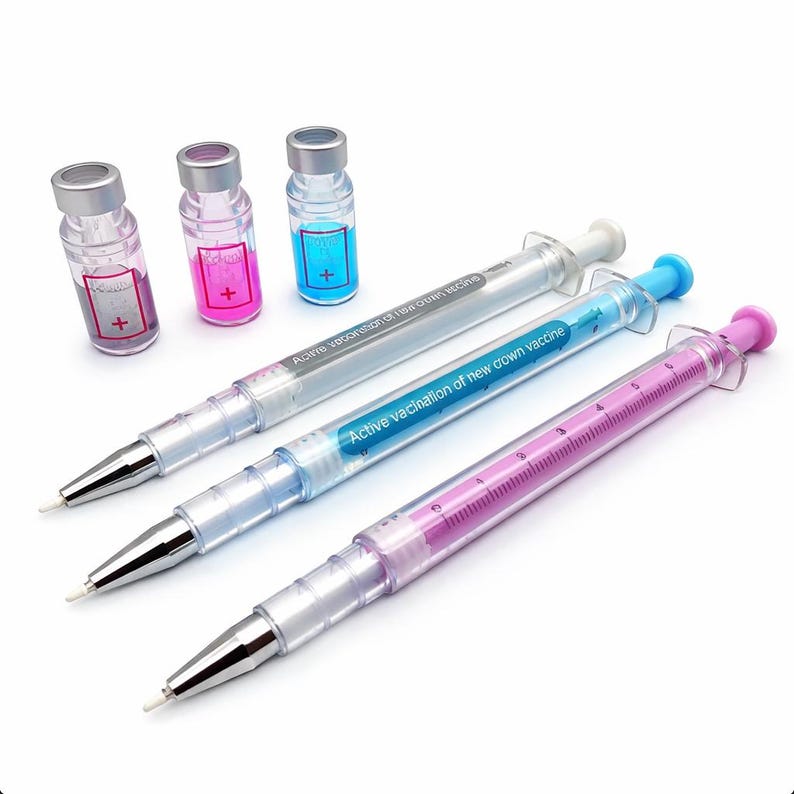May include: A collection of novelty pens and vials. The pens are designed to resemble syringes, with clear barrels and colored plungers. The vials are small, clear bottles with colored liquid inside. The text on the pens reads "Active vaccination of new crown vaccine."