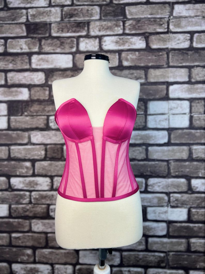 May include: A pink satin and mesh corset with a sweetheart neckline.