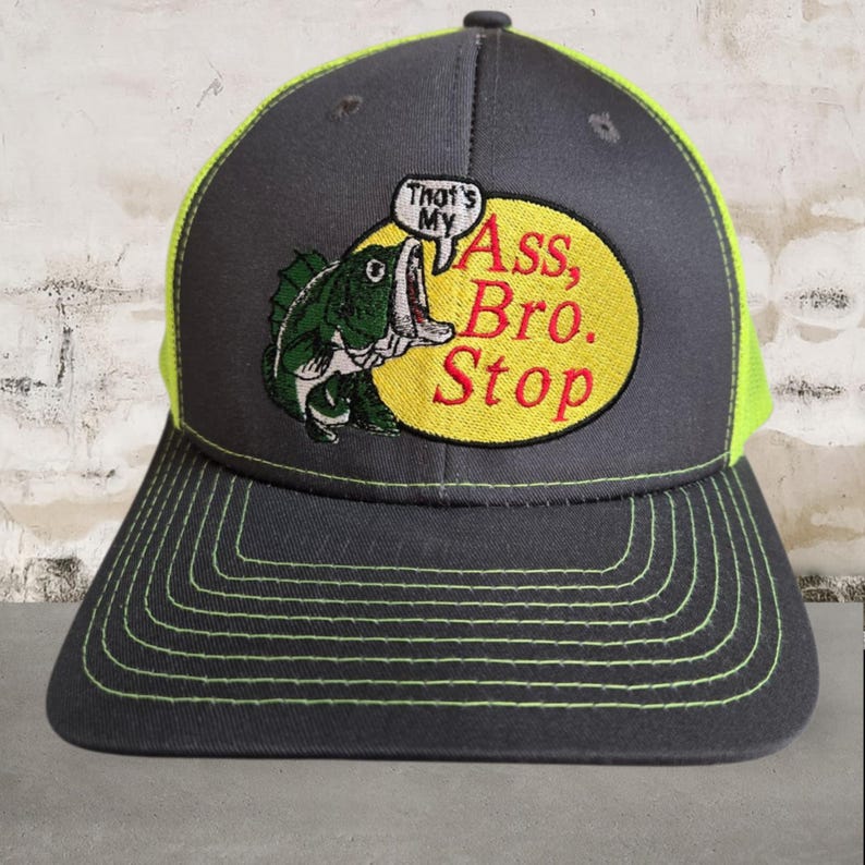 May include: A grey baseball cap with a neon green mesh back and brim stitching. The front features a yellow oval with a green fish graphic and the text "That's My Ass, Bro. Stop" in red and white.