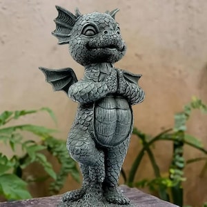 May include: A detailed, gray dragon statue with folded hands, wings, and a textured body. The dragon has a friendly expression and is standing on a stone base. The statue is a decorative garden ornament.