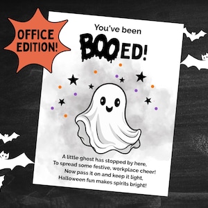 May include: A Halloween-themed print with a cartoon ghost and the words "You've been BOOED!" in black. The print includes orange, purple, and black accents, with the text "OFFICE EDITION!" in an orange starburst. A poem about Halloween is also included.