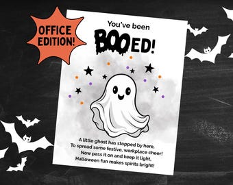 May include: A Halloween-themed print with a cartoon ghost and the words "You've been BOOED!" in black. The print includes orange, purple, and black accents, with the text "OFFICE EDITION!" in an orange starburst. A poem about Halloween is also included.
