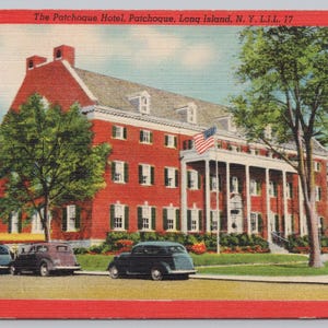 May include: Vintage postcard featuring The Patchogue Hotel in Patchogue, Long Island, NY. The red brick building has a white columned entrance and an American flag. Three vintage cars are parked in front of the hotel.
