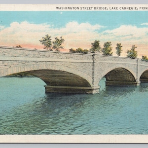May include: Vintage postcard featuring the Washington Street Bridge over Lake Carnegie in Princeton, NJ. The stone bridge has multiple arches over the water. The sky is blue with some clouds and the water is a teal color.