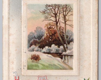 May include: Vintage Christmas card with a winter landscape scene. The card features a rectangular image of trees and a river, framed by a silver border with holly and berries. The words "Hearty Wishes for Christmas" are printed in red.