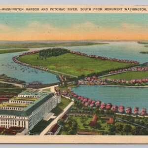 May include: Vintage postcard featuring a scenic view of Washington Harbor and the Potomac River, south from Monument Washington, D.C. The image shows a river, green land, buildings, and a bridge. The sky is a mix of blue and yellow.