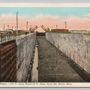 May include: Vintage postcard of the Sabin Lock in Sault Ste. Marie, Michigan. The empty lock is 1,350 ft. long with 50 ft. deep walls. The image shows the lock's concrete walls and the open drawbridges. The sky is a mix of pink and blue.