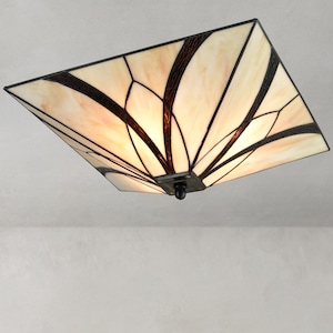 May include: Square ceiling light fixture with a stained glass design. The light has a cream-colored background with dark brown and black geometric patterns. The fixture is mounted on a white ceiling.