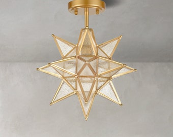 May include: Gold ceiling light fixture shaped like a star with clear glass panels.