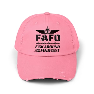 May include: Pink distressed baseball cap with black embroidered text that reads "FAFO F*CK AROUND AND FIND OUT" with a skull and wings graphic.