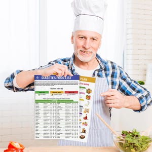 Puede incluir: Un hombre con un gorro de cocinero y un delantal sostiene un gr&aacute;fico laminado titulado "Lista de alimentos para diab&eacute;ticos" con un gr&aacute;fico de &iacute;ndice gluc&eacute;mico (IG). El gr&aacute;fico enumera varios alimentos y sus valores de IG correspondientes. El gr&aacute;fico est&aacute; dividido en tres categor&iacute;as: IG bajo, IG medio e IG alto.