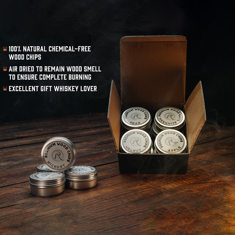 May include: A set of 10 small metal tins filled with wood chips for smoking. The tins are arranged in a box and labeled with different wood types, including hickory, pear, mesquite, walnut, and apple.  The text on the tins reads "Premium Wood Chips".