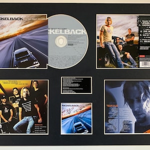 Op de afbeelding: Een ingelijste presentatie met een Nickelback albumhoes, een cd en bandfoto's. De albumhoes toont een zwarte auto op een snelweg. De cd is zilverkleurig. Foto's van de bandleden zijn ook inbegrepen.