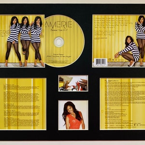 Puede incluir: Una portada de álbum de CD con fondo negro y un patrón de rayas amarillas. El álbum se titula "Amerie: Because I Love It". La portada presenta una foto de tres mujeres con tops a rayas blancas y negras y pantalones negros. La portada del álbum también incluye una foto de una mujer con un top a rayas blancas y negras y pantalones negros, sentada en el suelo. La portada del álbum también incluye una foto de una mujer con un top rojo y pantalones negros.