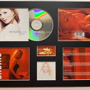 May include: A framed CD set of Geri Halliwell's album "Schizophonic". The set includes the CD, the front and back covers, and a photo of Geri Halliwell.