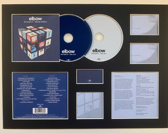 Può includere: Un display incorniciato nero con due CD e un libretto di CD. I CD sono etichettati "Elbow, The Best of, Disc One" e "Elbow, The Best of, Disc Two". Il libretto di CD è etichettato "Elbow, The Best of, Deluxe Edition".