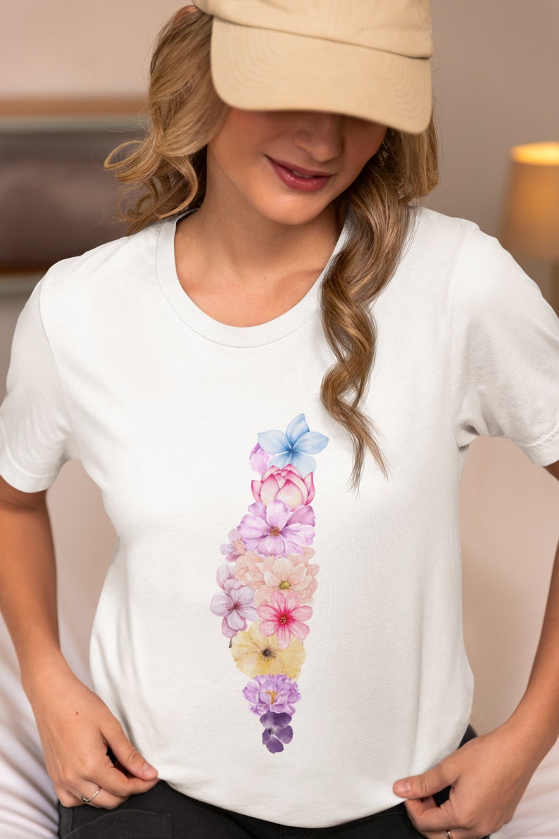 May include: A white t-shirt with a vertical floral design. The flowers are in shades of pink, purple, blue, and yellow. The flowers are arranged in a cascading pattern, starting at the top of the shirt and ending at the bottom.