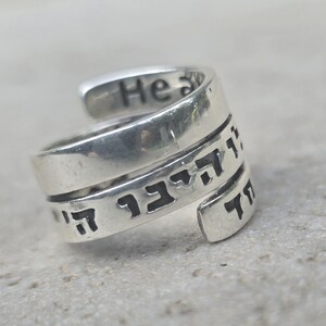 May include: Silver ring with Hebrew text and the words "He is" engraved on the band.