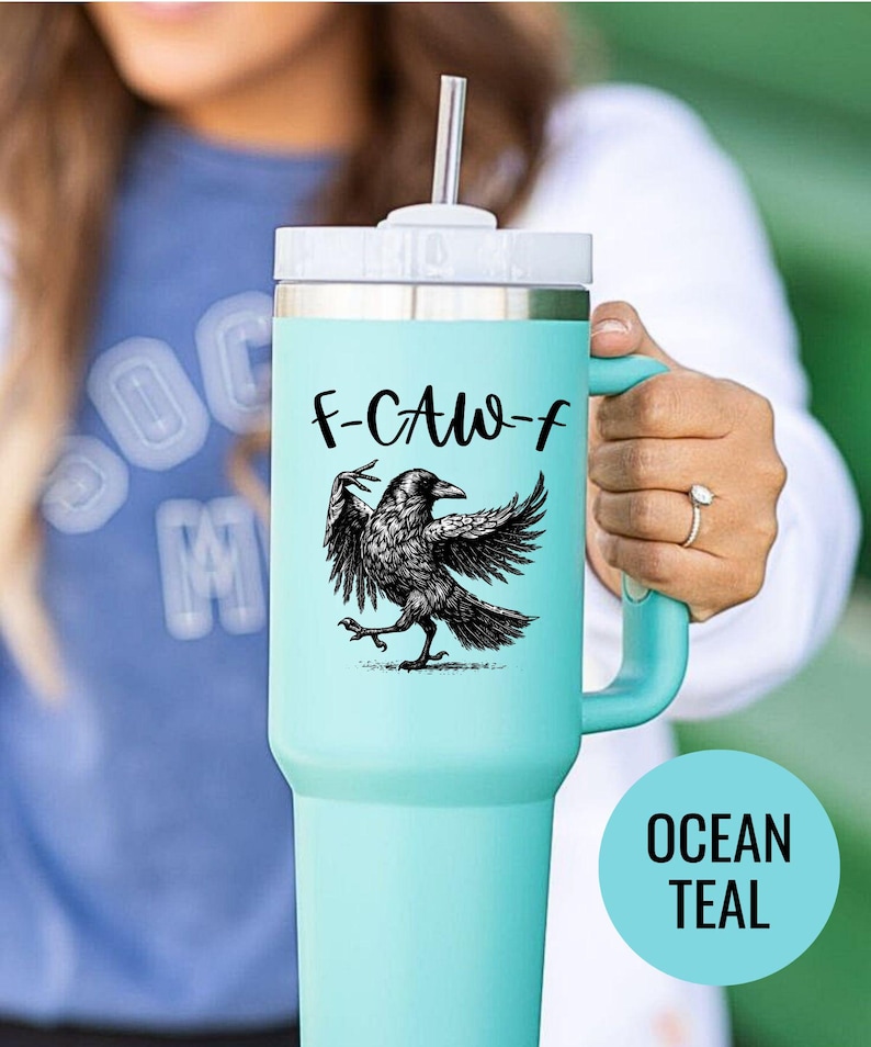 A stainless steel insulated tumbler featuring a detailed black raven illustration with wings spread, paired with the phrase "F-Caw-F" in playful script; the design blends gothic and humorous elements, creating a unique travel cup for bird enthusiasts, crow lovers, or fans of dark sarcastic quotes; shown on tumblers in various matte finishes, each with a handle and straw for practical everyday use.