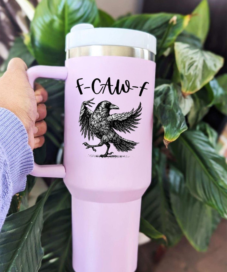 A stainless steel insulated tumbler featuring a detailed black raven illustration with wings spread, paired with the phrase "F-Caw-F" in playful script; the design blends gothic and humorous elements, creating a unique travel cup for bird enthusiasts, crow lovers, or fans of dark sarcastic quotes; shown on tumblers in various matte finishes, each with a handle and straw for practical everyday use.