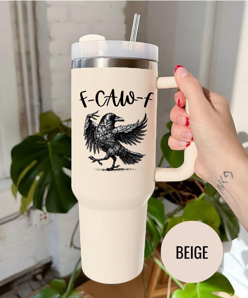 A stainless steel insulated tumbler featuring a detailed black raven illustration with wings spread, paired with the phrase "F-Caw-F" in playful script; the design blends gothic and humorous elements, creating a unique travel cup for bird enthusiasts, crow lovers, or fans of dark sarcastic quotes; shown on tumblers in various matte finishes, each with a handle and straw for practical everyday use.