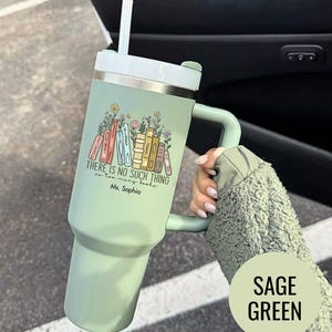 May include: Sage green insulated tumbler with a handle and straw. The tumbler features a design of colorful books and flowers, with the text "THERE IS NO SUCH THING as too many books" and "Ms. Sophia".