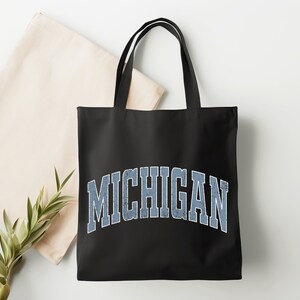 May include: Black canvas tote bag with a blue and white vintage-style "MICHIGAN" graphic.