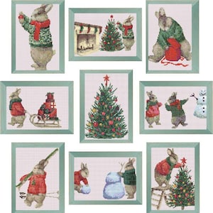 Könnte beinhalten: Eine Sammlung gerahmter Kreuzstich-Kunstwerke, die Hasen bei verschiedenen Weihnachtsaktivitäten zeigen. Szenen umfassen das Schmücken eines Baumes, das Bauen eines Schneemanns und das Ziehen eines Schlittens mit Geschenken. Die Rahmen sind in einem gedämpften Grün gehalten.