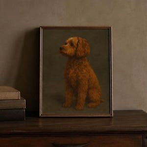 Könnte beinhalten: Ein gerahmtes Porträtgemälde eines goldbraunen, lockigen Hundes, der im Profil vor einem dunklen, gedeckten olivgrünen Hintergrund sitzt. Das Kunstwerk ist in einem dünnen, dunkel gehaltenen Rahmen gefasst und zeigt den aufmerksamen Blick.