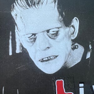 May include: Black and white image of Frankenstein's monster with a red sticker that says "L" on his chest. The sticker is dripping red paint.