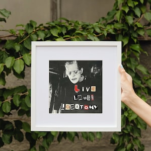 May include: A black and white framed print of a man with a Frankenstein-like appearance. The print features the text "Live Laugh Loeotomy" in a collage style.