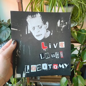 May include: Black and white image of a monster with the words "Live Laugh Lobotomy" in red, black, and white letters.