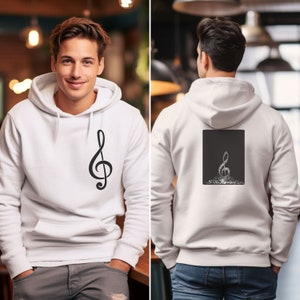 Puede incluir: Sudadera blanca con un gráfico de clave de sol negro en la parte delantera y un gráfico de clave de sol negro hecho de puntos blancos en la parte trasera.