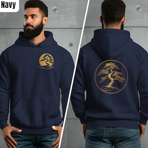 Peut inclure: Sweat-shirt à capuche bleu marine avec un motif d'arbre bonsaï doré sur le dos et une version plus petite du motif sur la poitrine gauche. Le sweat-shirt a une capuche avec cordon de serrage et une poche kangourou.