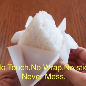 May include: White rice is being pressed into a white plastic mold. The mold is shaped like a triangle and has a flap that folds over the rice. The text "No Touch, No Wrap, No Stick Never Mess." is visible in the image.