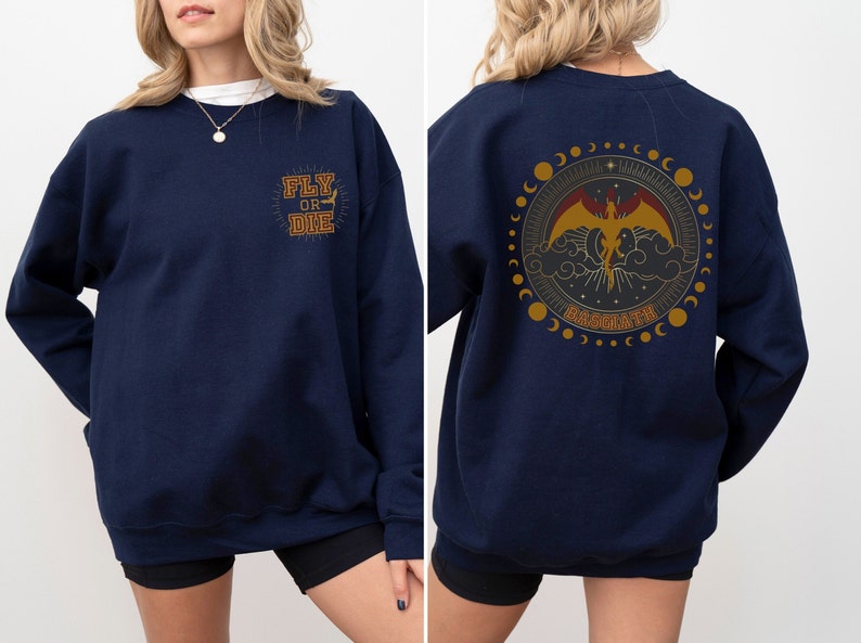 May include: Navy blue sweatshirt with gold text that says "FLY OR DIE" on the front. The back features a circular design with a dragon, clouds, and the word "BASMATH".