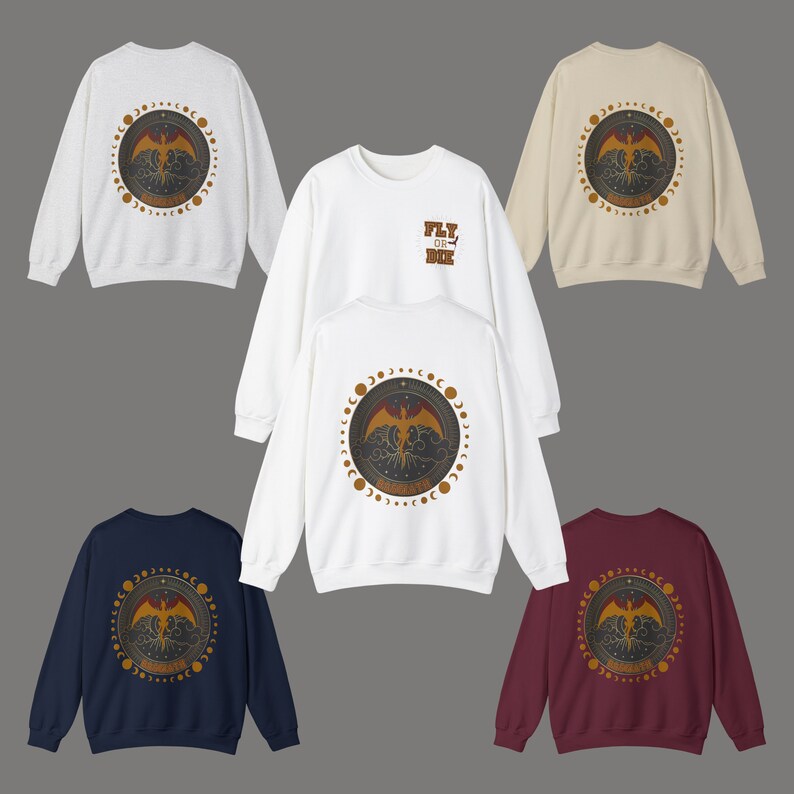 May include: A collection of crewneck sweatshirts in various colors, including white, navy, and burgundy. Each sweatshirt features a circular graphic on the back with a phoenix design and the text "REBIRTH". One white sweatshirt has "FLY OR DIE" on the front.