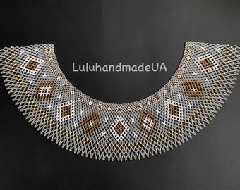 May include: A beaded collar necklace with a geometric pattern. The necklace features a grey, white, and brown diamond design. The text "LuluhandmadeUA" is visible on the image. The necklace is on a dark background.