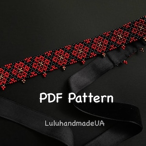 Op de afbeelding: Een met kralen bezette hoofdband met een bloemmotief in rood, zwart en goud. De hoofdband ligt op een zwarte achtergrond met een zwart lint. De tekst "PDF Pattern" en "LuluhandmadeUA" zijn ook zichtbaar.