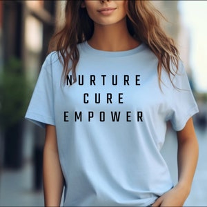 May include: A light blue t-shirt with the words "NURTURE CURE EMPOWER" printed in black.