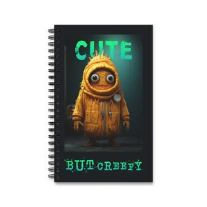 May include: A black and white spiral notebook with a yellow creature wearing a yellow raincoat and the text "CUTE BUT CREEPY" on the cover.