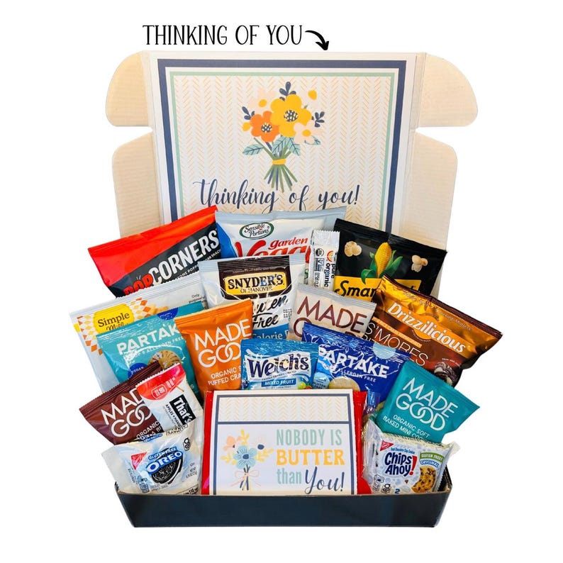 May include: A gift basket filled with various snacks, including chips, cookies, and popcorn. The box features a floral design and the text "Thinking of You." A card inside reads "Nobody is Butter Than You!"